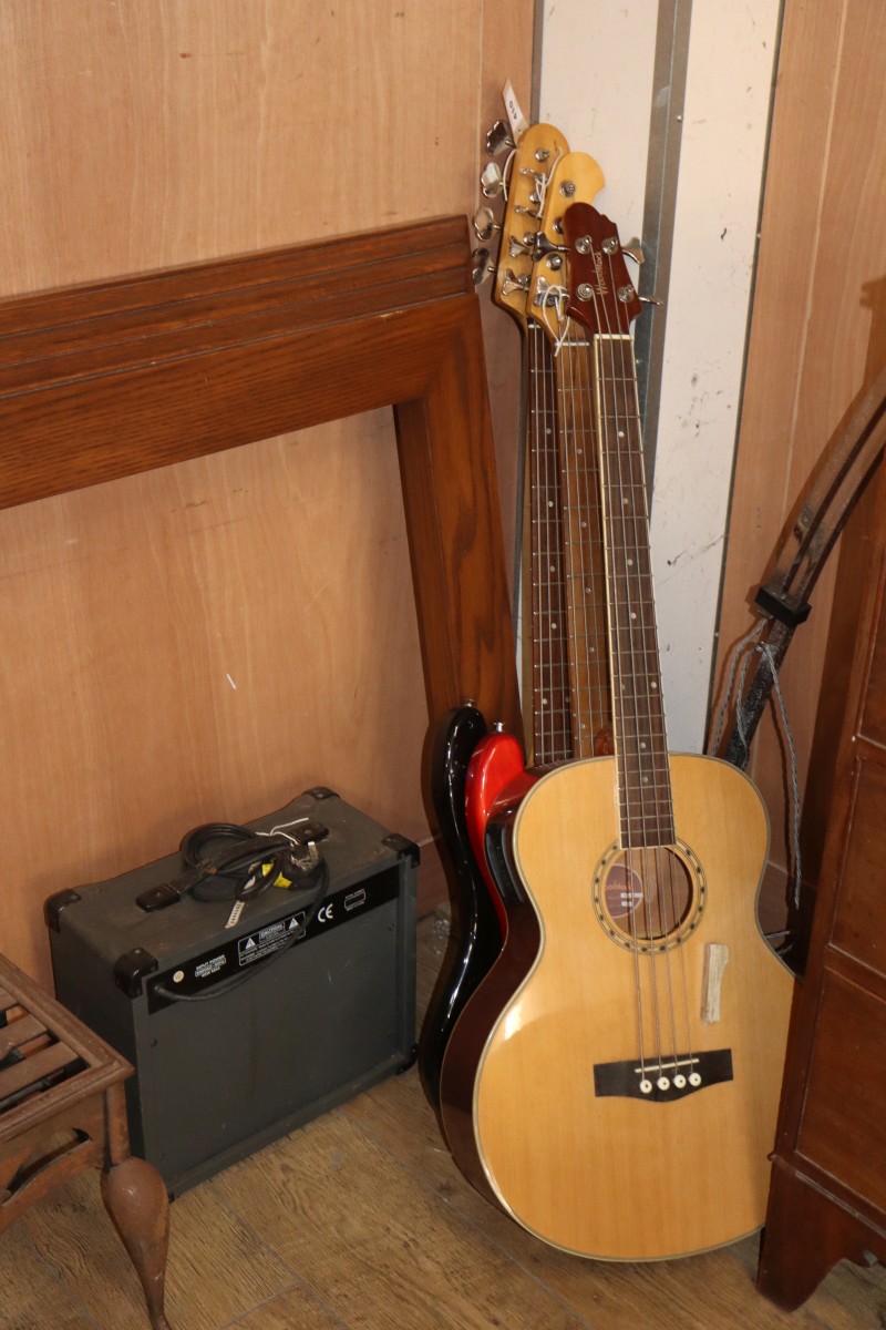 A Squier P-Bass guitar, a Harley Benton electric bass guitar, a Woodstock electro acoustic bass guitar and a Rocket 2013 bass guitar am